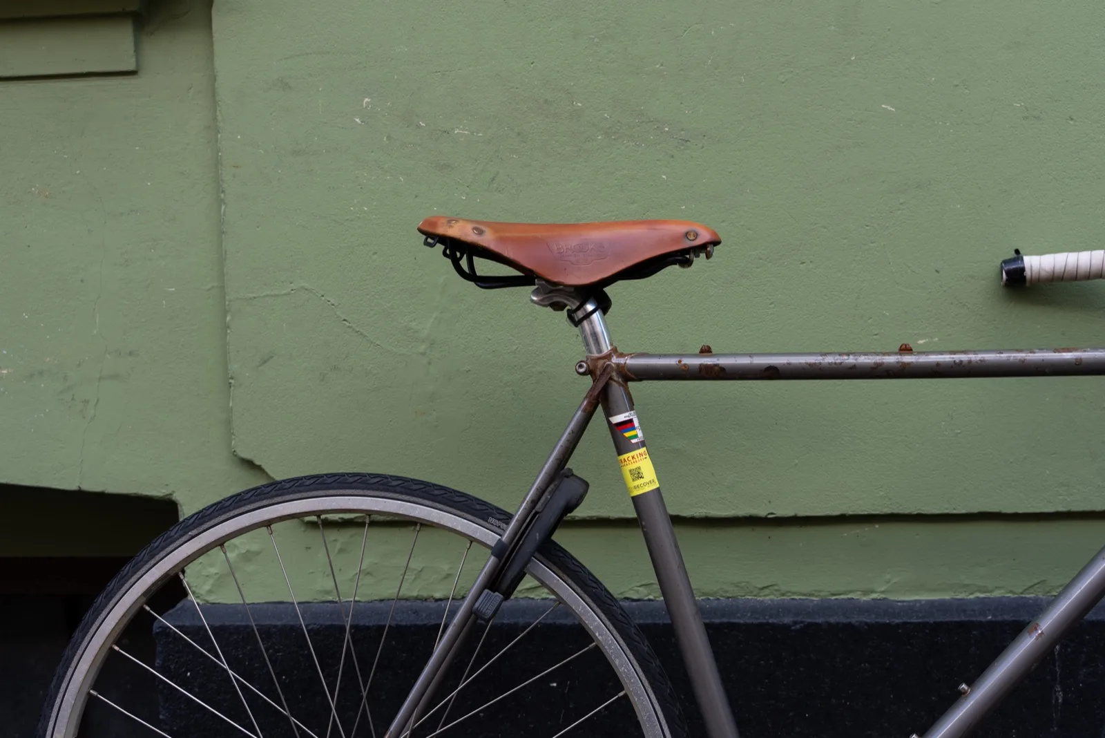 A vintage singlespeed bike with a Brooks leather saddle and an ItemRecover QR tag on the seat post