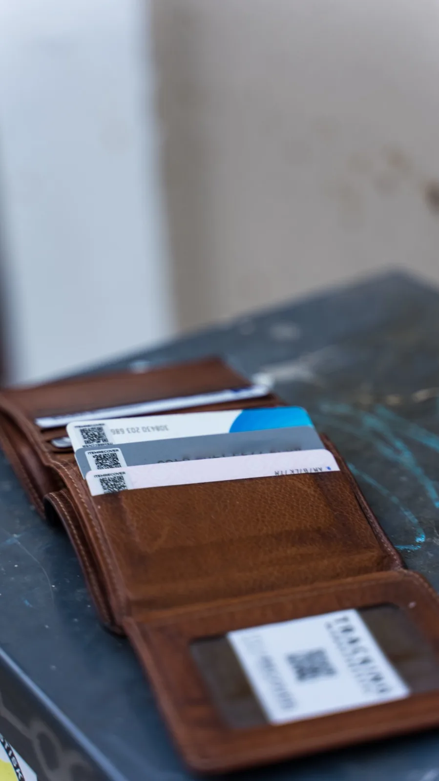 An open leather wallet on a dark surface, with a small ItemRecover tag on the back